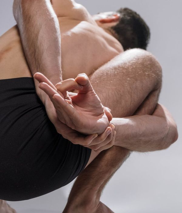 Man performing a controlled stretching movement in a calm, focused environment.